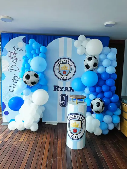 A Manchester City football club theme for a 9th birthday. Perfect for a young sports fan, this setup includes the team logo, colors, and soccer ball balloons.