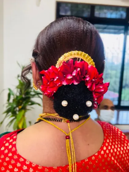 Another view of the beautiful floral bun. Using fresh or high-quality artificial flowers can elevate any traditional hairstyle.