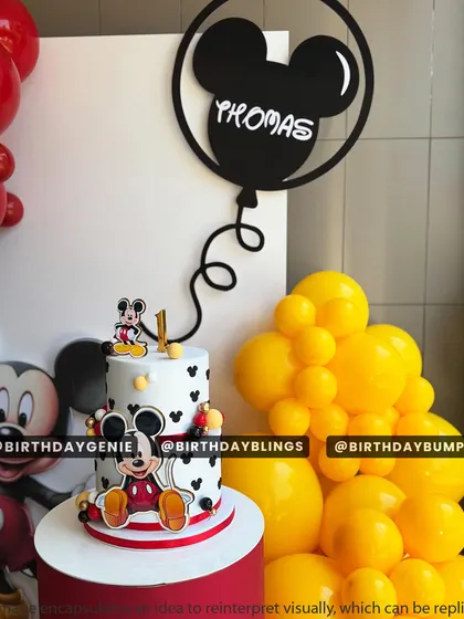 A close-up of the adorable, two-tiered Mickey Mouse cake, perfectly matching the party's theme.