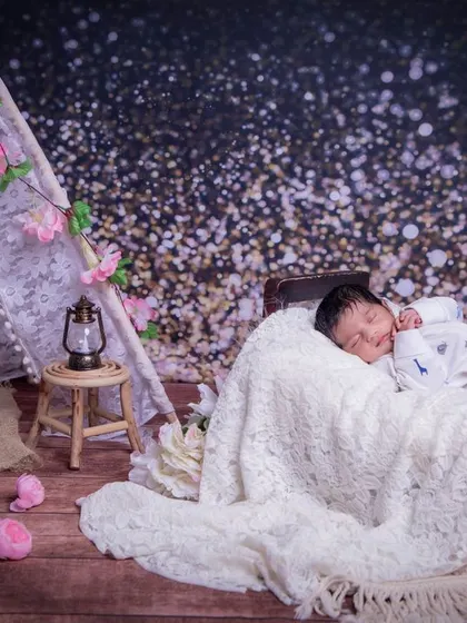 Dreaming under the stars. This setup uses a beautiful, sparkly backdrop to create a magical, celestial scene for this sleeping baby.