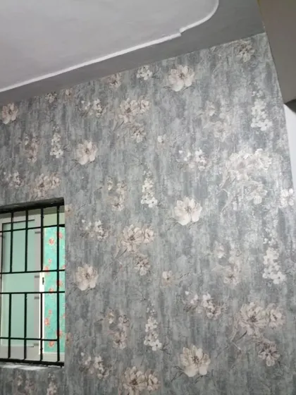 A textured floral wallpaper in grey tones.