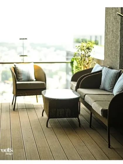 This high-rise balcony is converted into a comfortable lounge with elegant wicker furniture. It provides a serene spot to enjoy the expansive city view, proving that even elevated spaces can become tranquil retreats.