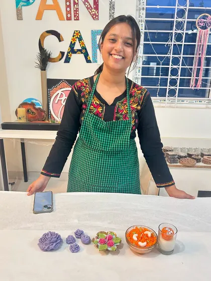 A guest showcasing the variety of candles you can learn to make in our workshop, from floral designs to dessert-inspired creations.