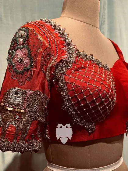 A stunning red silk corset blouse with Paithani artistry, featuring embroidered elephants and floral motifs for a regal yet modern look.