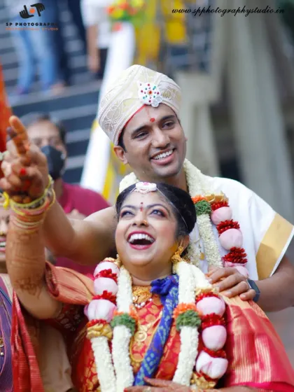 A moment of pure celebration and joy. The couple's ecstatic expressions as they are surrounded by family capture the peak excitement of the wedding day.