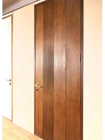 This minimalist door features vertical panels of natural wood with a subtle fluted texture, adding a touch of elegance without overwhelming the space.