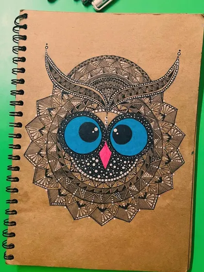 An owl mandala drawn on brown paper, giving it a rustic and earthy feel.