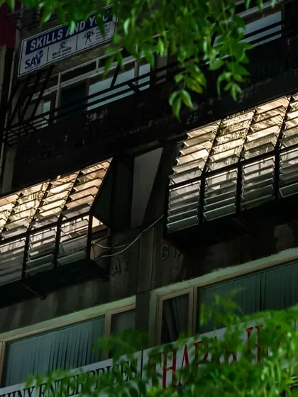 The adjustable aluminum louver system seen from the exterior of the AEEE office at night. The system acts as a dynamic facade, with the louvers glowing from the interior light while providing privacy and architectural texture.