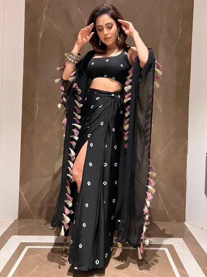 Here’s a boho-chic look I put together for Nushrratt Bharuccha. This black draped outfit with a thigh-high slit and tassel details is a great example of fusion wear that is both edgy and glamorous, perfect for a stylish evening event.