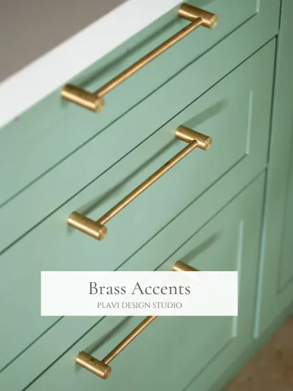 Brass accents, like these sleek cabinet handles, add a touch of warmth and luxury to this green kitchen. It's a small detail that makes a significant difference in the overall finish.