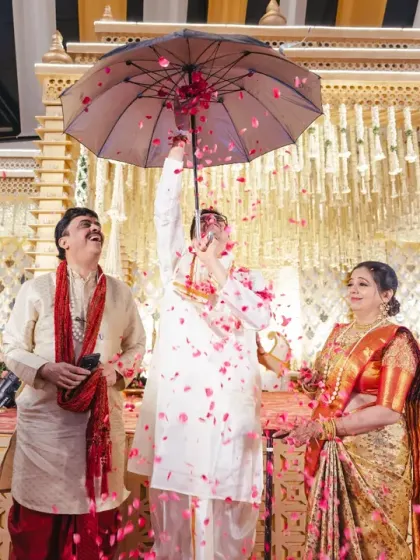 A unique ritual from a South Indian wedding, where the groom uses an umbrella to shower the bride with petals. This joyful and colourful moment makes for a fantastic photograph.