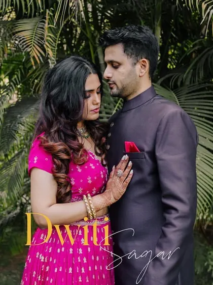 An intimate portrait of a couple in a quiet embrace, set against lush green foliage. This shot captures a moment of calm connection.