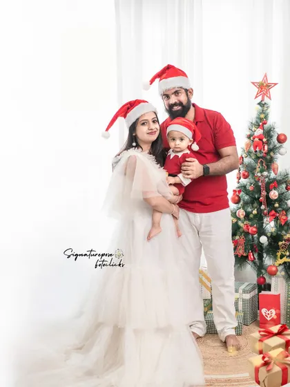 A classic Christmas family portrait. The family is dressed in festive colors, posing together in a beautifully decorated studio setting, creating the perfect image for a holiday card.