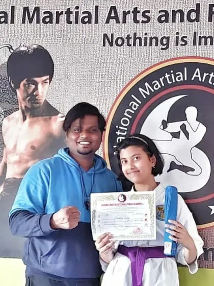A student proudly receives her purple belt, a senior rank that shows her dedication and expertise.