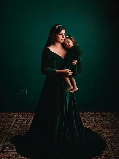 I love creating fine art portraits like this one. The deep green velvet, the soft lighting, and the gentle embrace create a timeless, painterly image that celebrates the profound connection between a mother and her daughter.