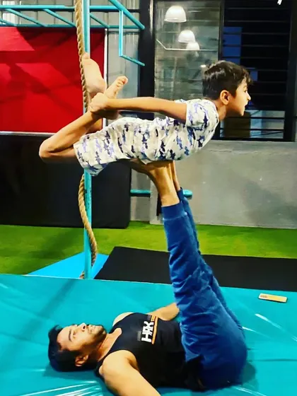 Here I am working with a young student on an acro-yoga pose called the "bow pose on feet". This helps kids develop body awareness and trust in their partner.