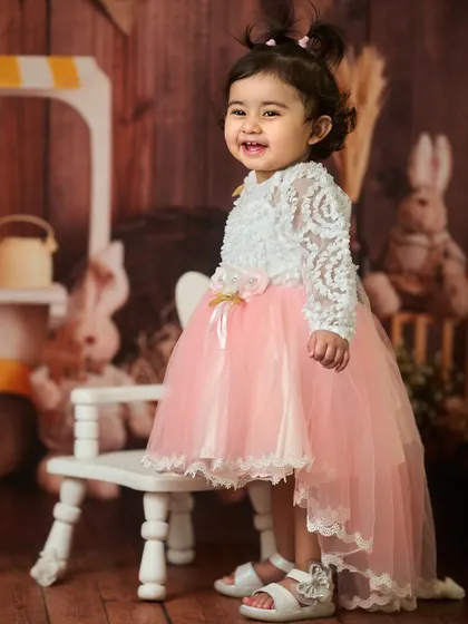A little princess in her beautiful party dress. This indoor portrait uses a rustic, barn-themed backdrop to create a warm and charming atmosphere for her photoshoot.