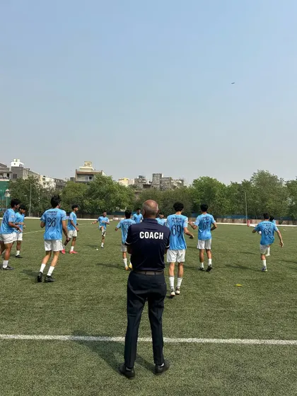 A coach watches over his players during a warm-up. This image captures the guidance and leadership that is central to our training philosophy.