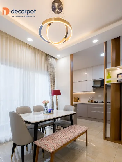 A view from the dining area into the kitchen, showcasing how a wooden partition with open shelves can create a sense of separation while maintaining an open and airy feel. The pendant lights add a modern, stylish touch.