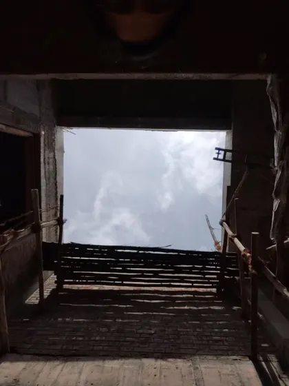 The dramatic silhouette of the unfinished structure against the clouds, showing the project's architectural ambition.