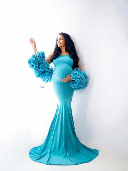 A full-length shot of our aqua blue Rosa gown against a clean white backdrop. This high-key lighting makes the color pop and creates a fresh, airy feel.