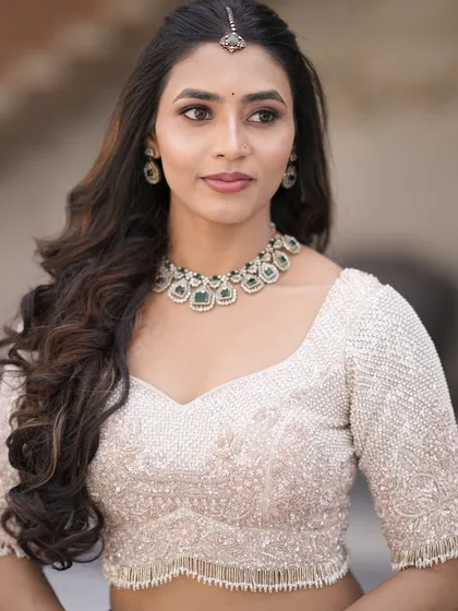 A detailed close-up of the ivory blouse, showcasing the intricate beadwork and a flattering sweetheart neckline.