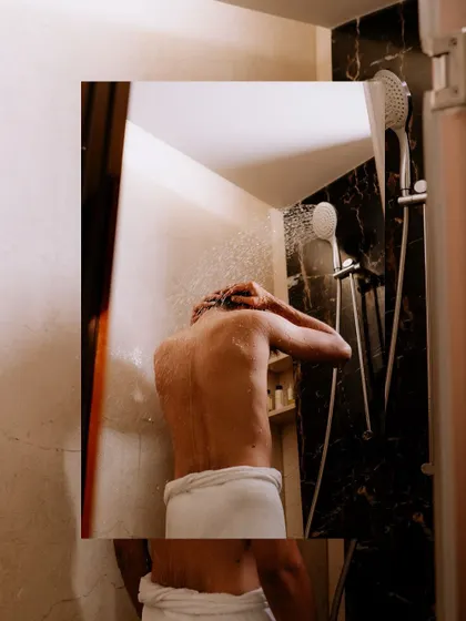 An artistic shot of the groom in the shower, part of a creative getting-ready sequence.