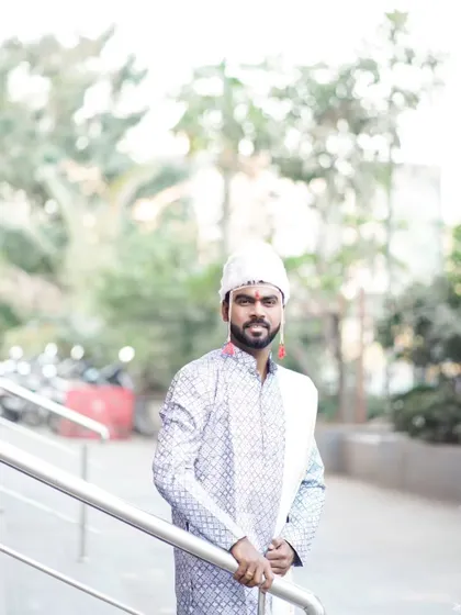 A classic portrait of the groom, looking directly at the camera with a confident smile.