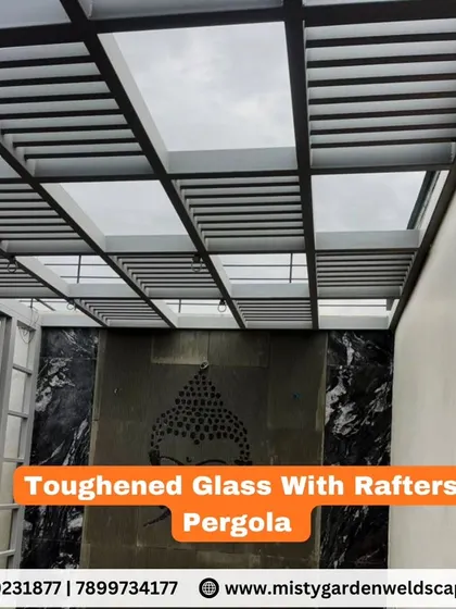 This pergola features toughened glass with integrated metal rafters. The rafters provide additional structural support and create a modern, linear aesthetic against the transparent glass.