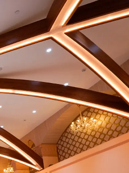 A detail shot of the timber-beamed ceiling, showcasing the blend of modern lighting and classic architectural design in our banquet hall.