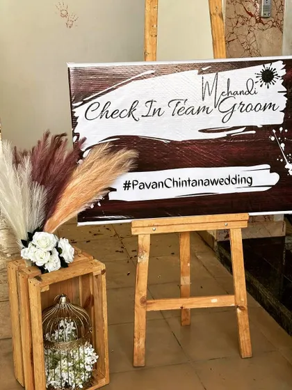 We also create fun, custom elements like this "Mehendi Check In Team Groom" sign, adding a playful and personal touch to the event.