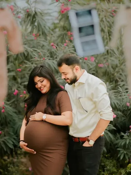 A happy couple moment during their outdoor pregnancy announcement shoot. The props in the background add a charming, rustic feel to the celebration.