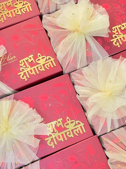 A collection of our vibrant red Diwali gift boxes, adorned with "Shubh Deepawali" in golden script and finished with delicate tulle bows.
