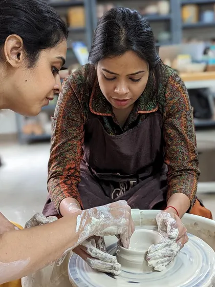 Showing a student how to shape the clay is a key part of our hands-on teaching approach.