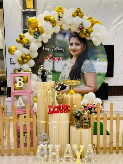 We can make your celebration extra personal. For this event, we designed a setup around a large custom portrait of the mom-to-be, framed by a white and gold balloon arch, a picket fence, and light-up letters spelling her name.