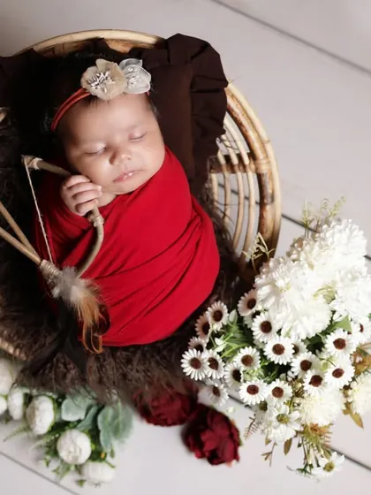 A little cupid theme for this newborn shoot. The tiny bow and arrow prop adds a touch of playful charm to this adorable baby portrait.