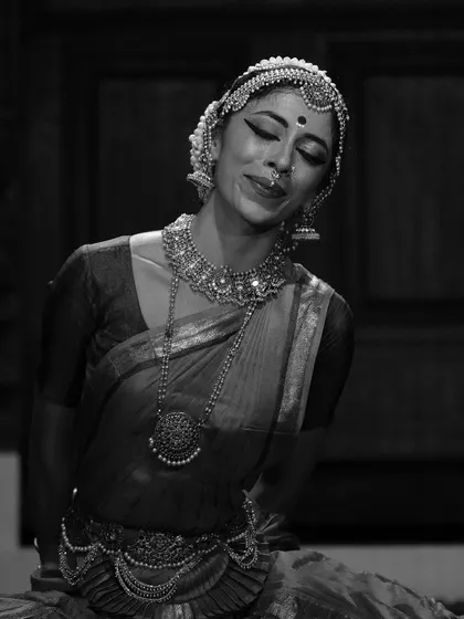 A black and white portrait capturing a moment of quiet contemplation and inner peace. The intricate jewelry and serene expression are the focus.