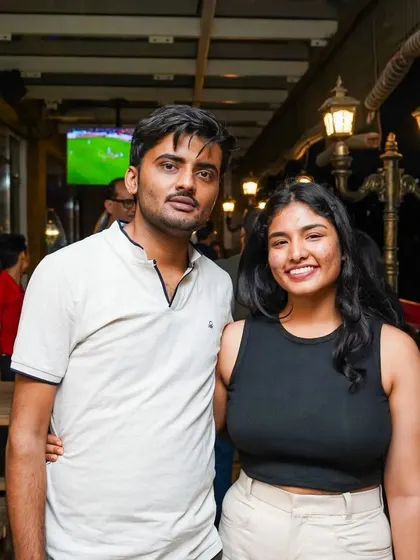 Guests posing for a photo during a night out. In the background, you can see one of the screens that are placed throughout the venue, ensuring you don't miss any of the live sports action.
