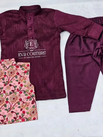 A similar three-piece set with a maroon kurta and pajama. The pink printed Nehru jacket adds a pop of color and pattern.