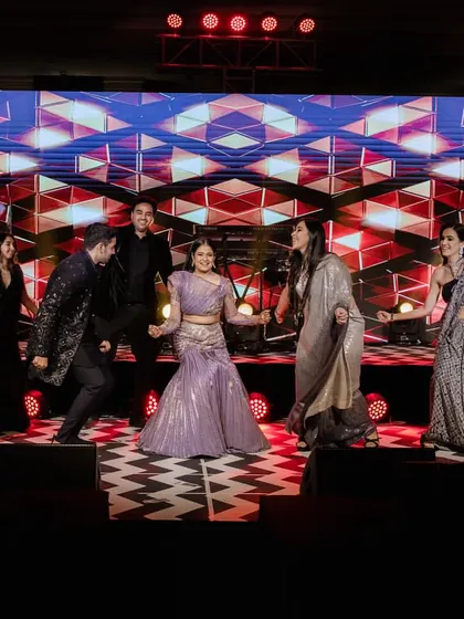 The bride and her friends enjoying a group dance. The checkered dance floor and LED screen add to the modern, fun vibe.