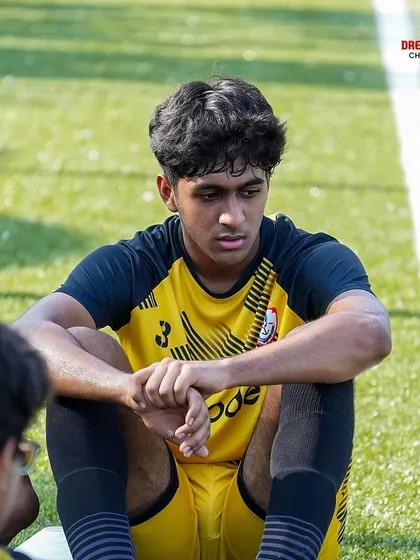 A candid moment of a player reflecting on the sidelines.