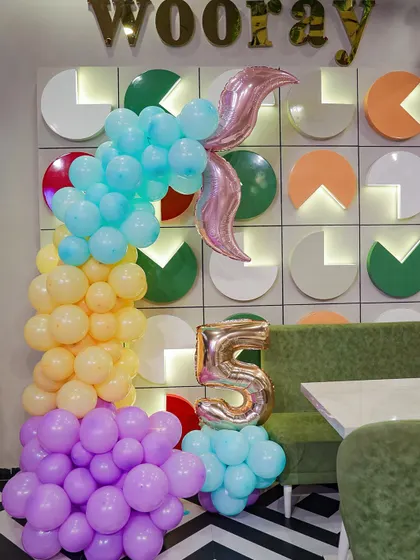 A stylish mermaid-themed balloon arrangement featuring a large mermaid tail balloon and a number 5, set against our signature "wooray" wall.