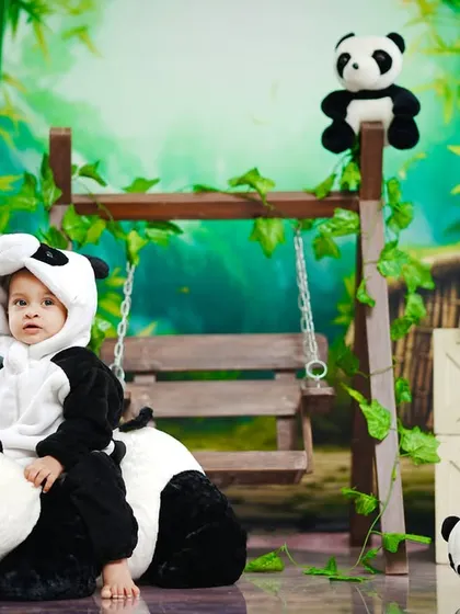 This little panda takes a ride on a bigger panda, creating a sweet and playful scene.