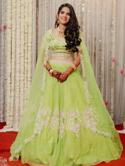 The full view of this bride's fresh and fun lime green engagement lehenga. The makeup is kept light and glowing, perfect for the occasion.