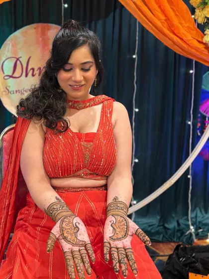 A candid moment of the bride admiring her beautiful peacock mehendi.