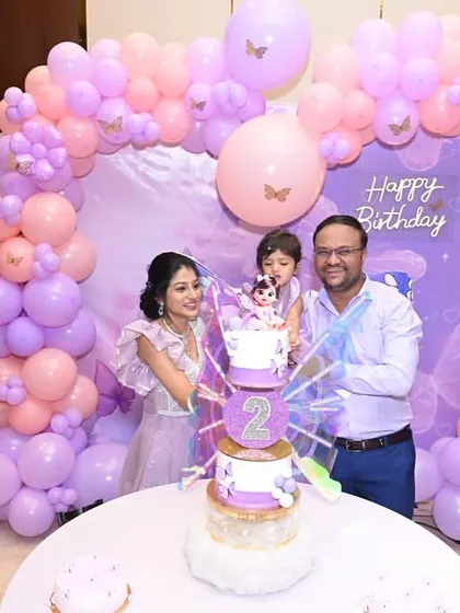 The family lights the candles on the butterfly cake, ready to make a wish.