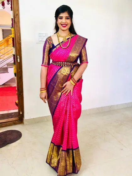 A forever favorite look for a treasured client. This vibrant pink and violet Kanchipuram silk saree is paired with a custom-designed blouse, creating a timeless and elegant ensemble for her special occasion.