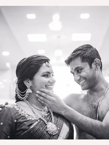 A tender moment between an expecting couple, captured in timeless black and white. The husband's gentle touch and their shared smile say it all.