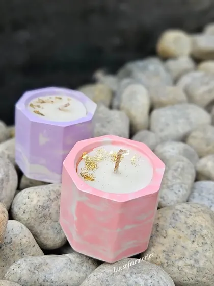 A pair of hexagon candles in pastel pink and lavender marble. These small candles are perfect for adding a subtle scent and a pop of color to any small space.