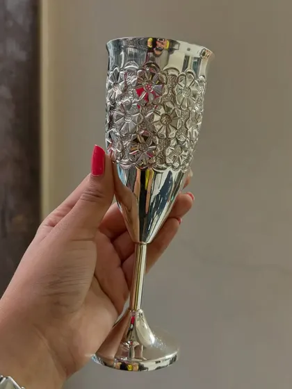 A hand holding our pure silver wine glass with a floral embossed pattern. This is a perfect gift for weddings, anniversaries, or for anyone who appreciates fine barware.